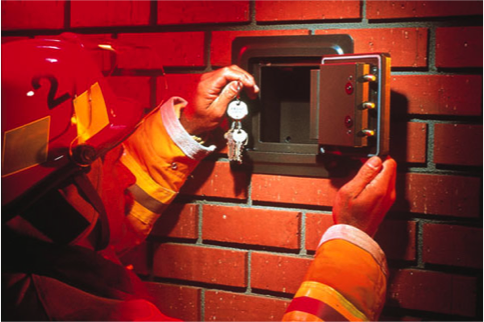 Person putting keys into a lock box in a wall